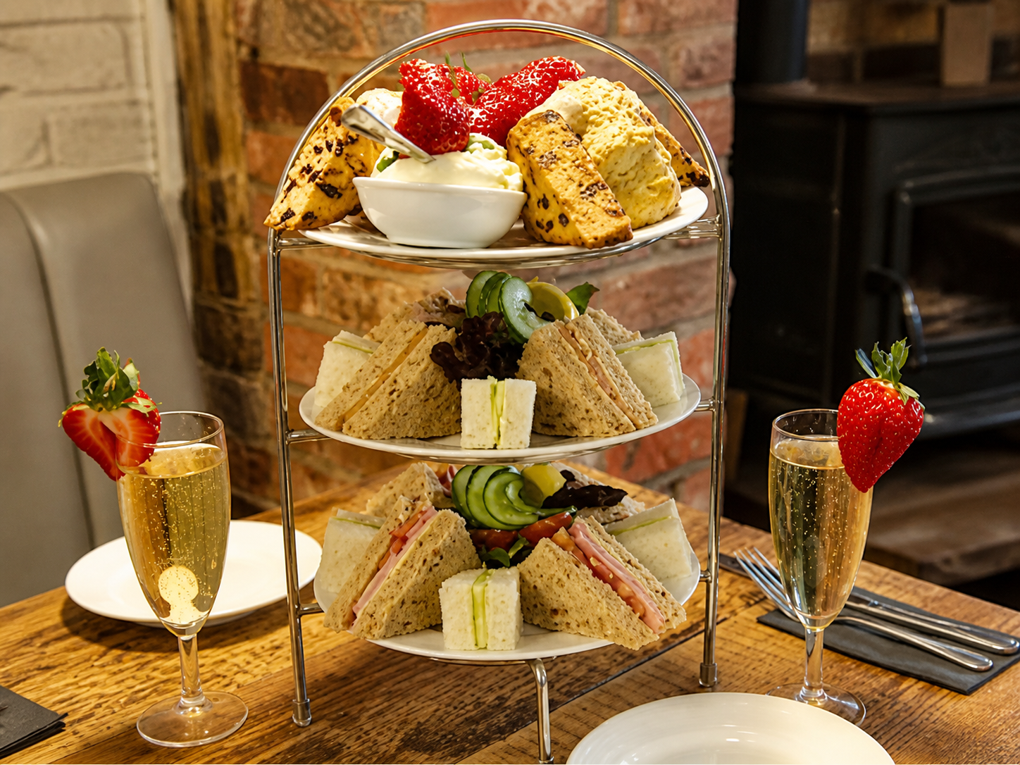 Concept presentation of afternoon tea with sandwiches, scones, strawberries and sparkling drinks